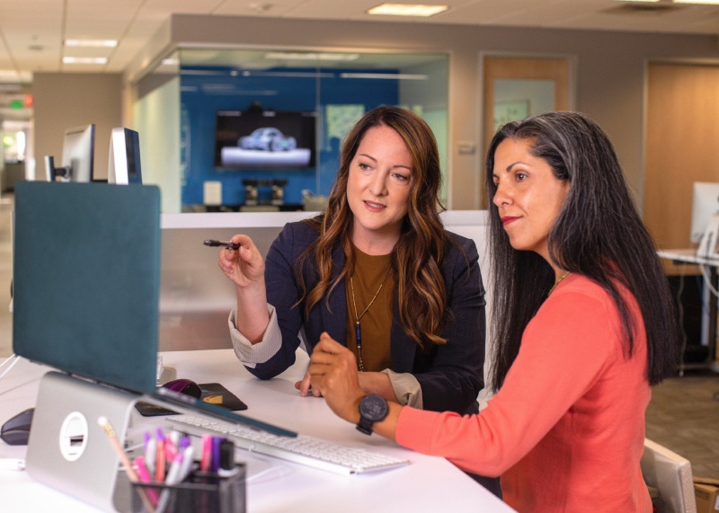 two women looking at a laptop